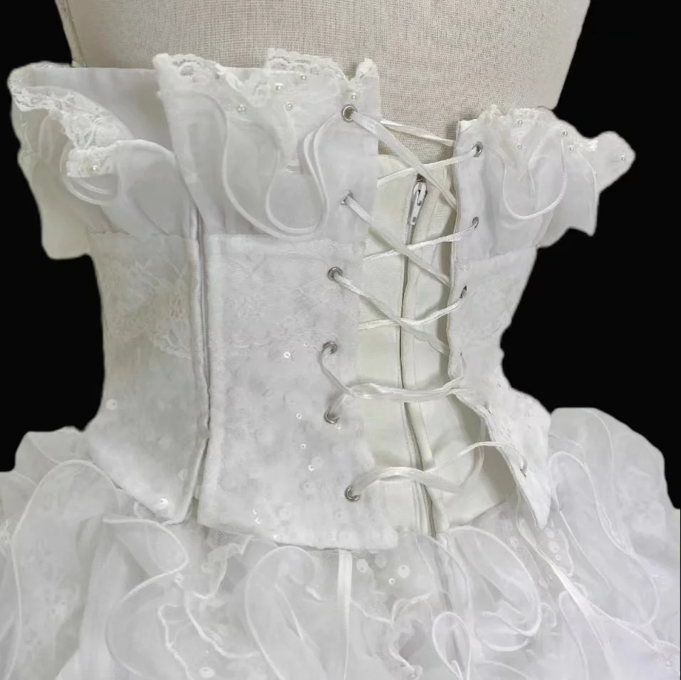 White strapless ball gown with a cinched waist and a voluminous tiered cake skirt; bridal gown R7300