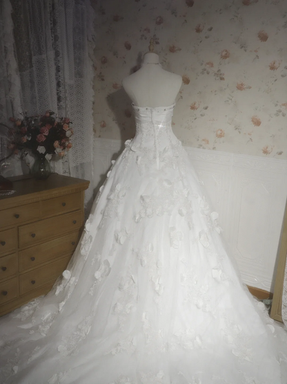 White strapless ball gown with a cinched waist and a voluminous puffy skirt; bridal gown R7291