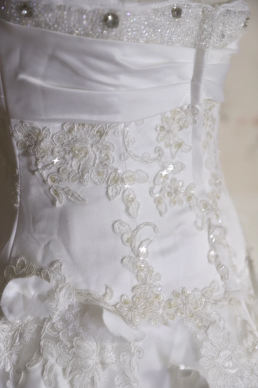 White strapless ball gown with a cinched waist and a voluminous puffy skirt; bridal gown R7291