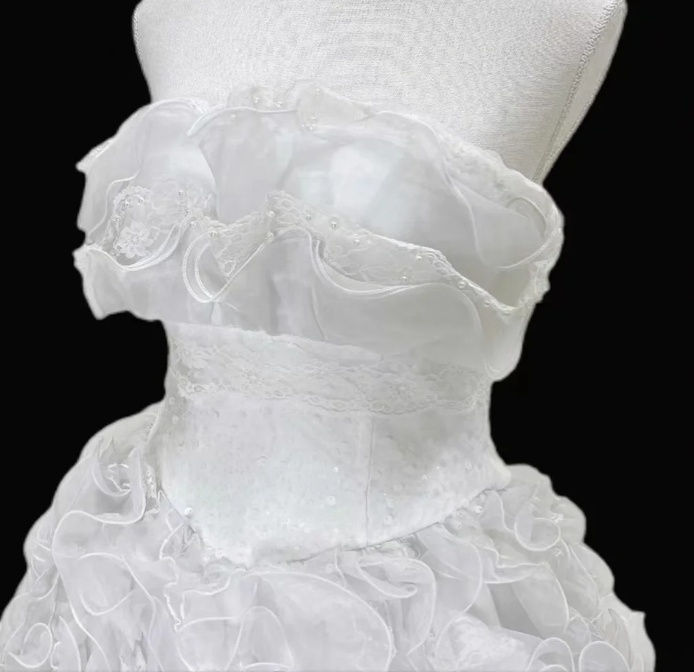 White strapless ball gown with a cinched waist and a voluminous tiered cake skirt; bridal gown R7300