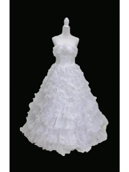 White strapless ball gown with a cinched waist and a voluminous tiered cake skirt; bridal gown R7300