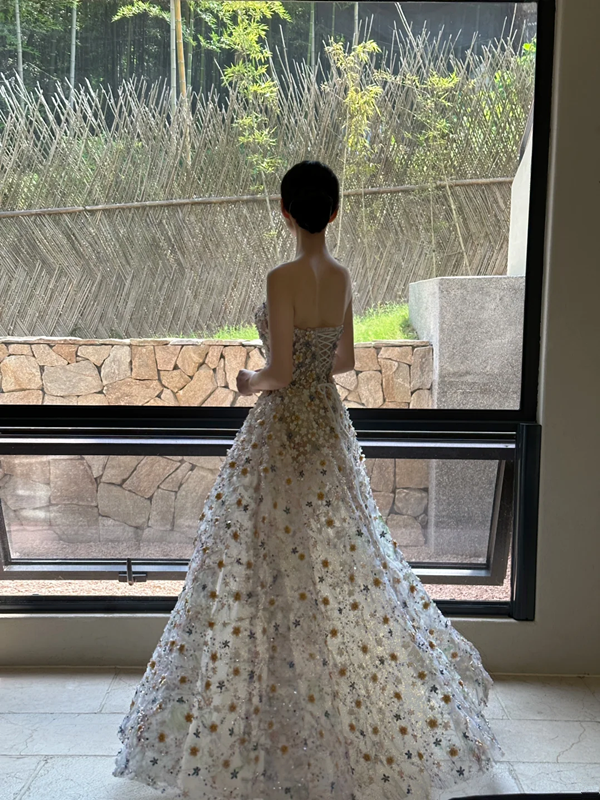 Sheer white base with appliqué, strapless, waist‑cinched, slim‑fit, long ball gown with a voluminous ruffled skirt R8015