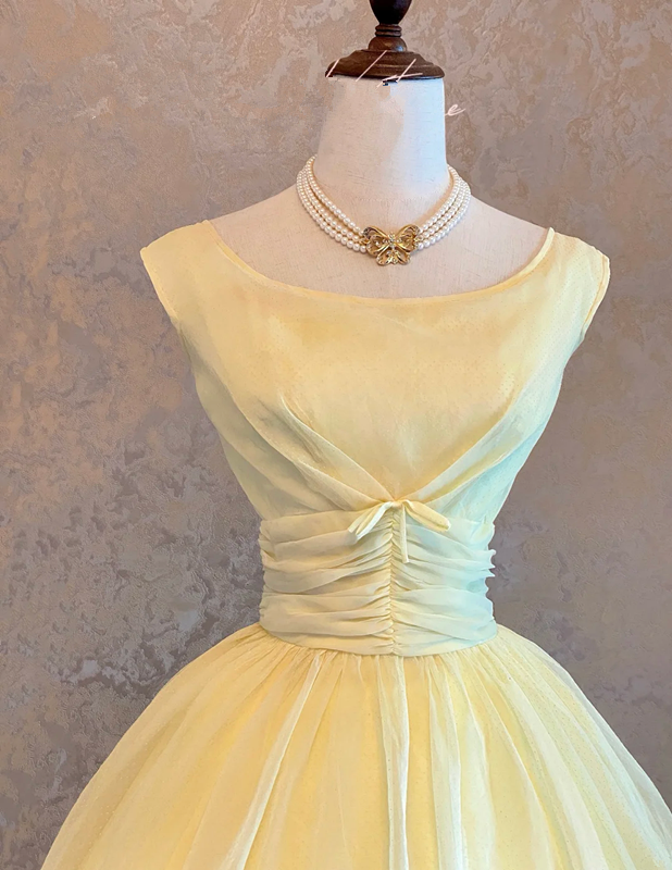Light yellow sleeveless ball gown with a cinched waist and a voluminous puffy skirt; bridal gown R7303